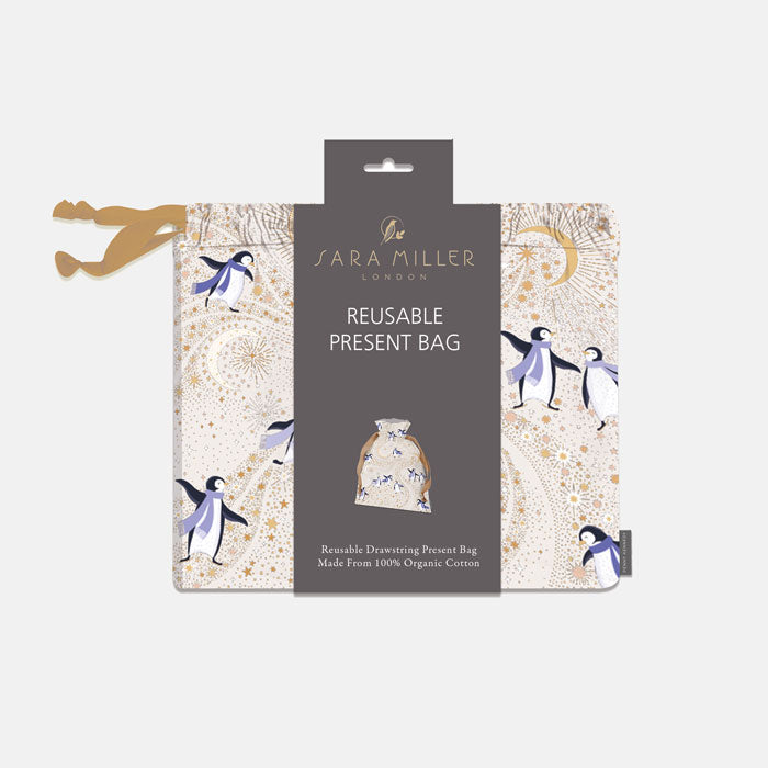 Sara Miller London reusable present bag in a cream and gold patterned design with penguins.