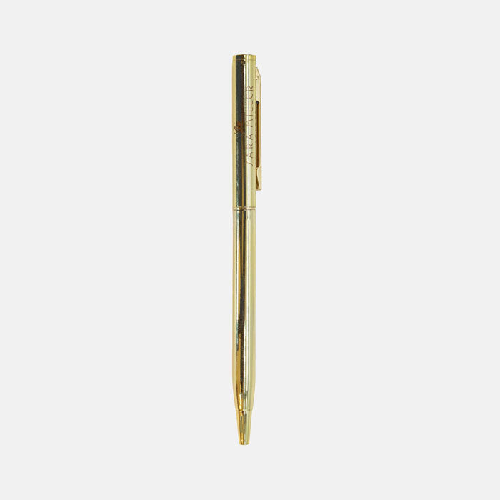Gold pen with Sara Miller London logo, twist mechanism.