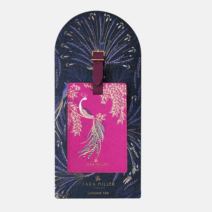 Fuchsia luggage tag with elegant bird design and gold detailing, presented on decorative card with peacock feathers design. 