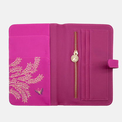 Inside of fuchsia travel wallet, shows card holders, zip pocket and large slots. Design continues inside.