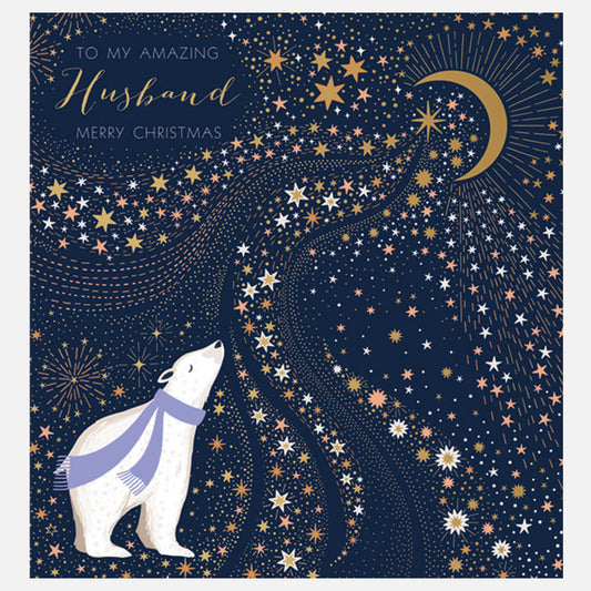 A square Christmas greeting card with a  polar bear wearing a purple scarf, gazing upward at a starry night sky. The card includes a gold crescent moon, many stars in white and gold, and the text 'TO MY AMAZING Husband MERRY CHRISTMAS' in the upper left.
