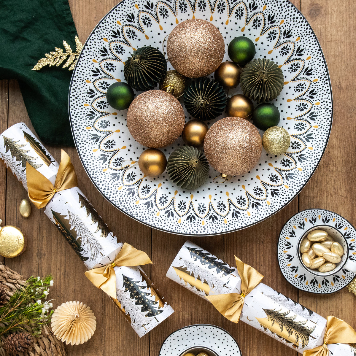 A large black and white serving bowl with delicate mandala pattern, filled with baubles.