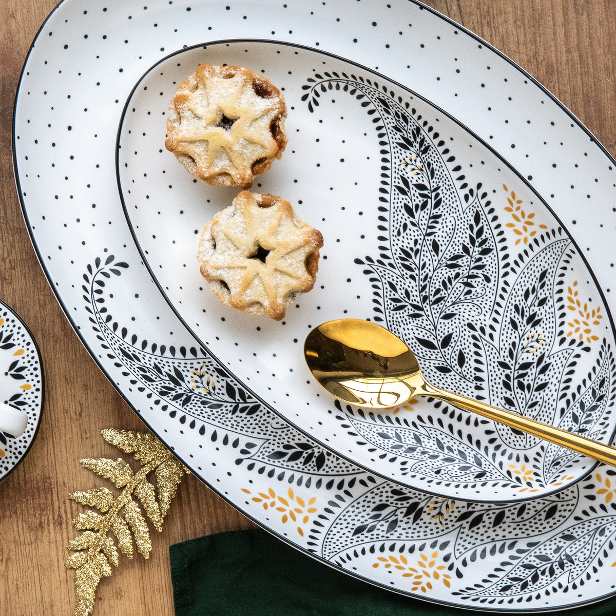 A stack of medium and large serving platters with black and white delicate patetrns.
