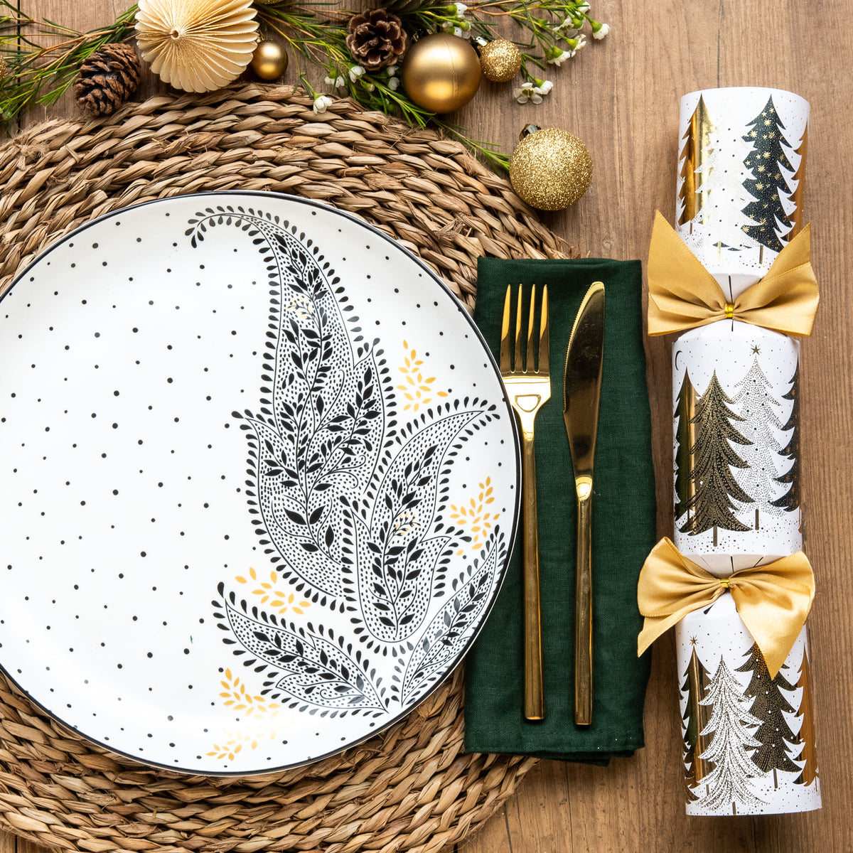 A black and white paisley patterned dinner plate set on a festive table setting.