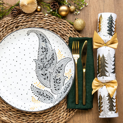 A black and white paisley patterned dinner plate set on a festive table setting.