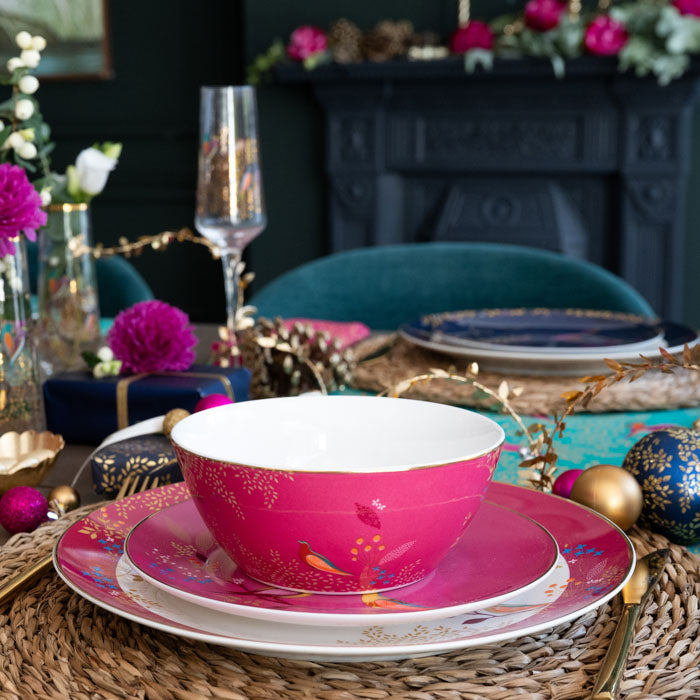 A pink bowl, side plate and dinner plate stacked in a festive place setting, items part of the wider 12 piece dining set.