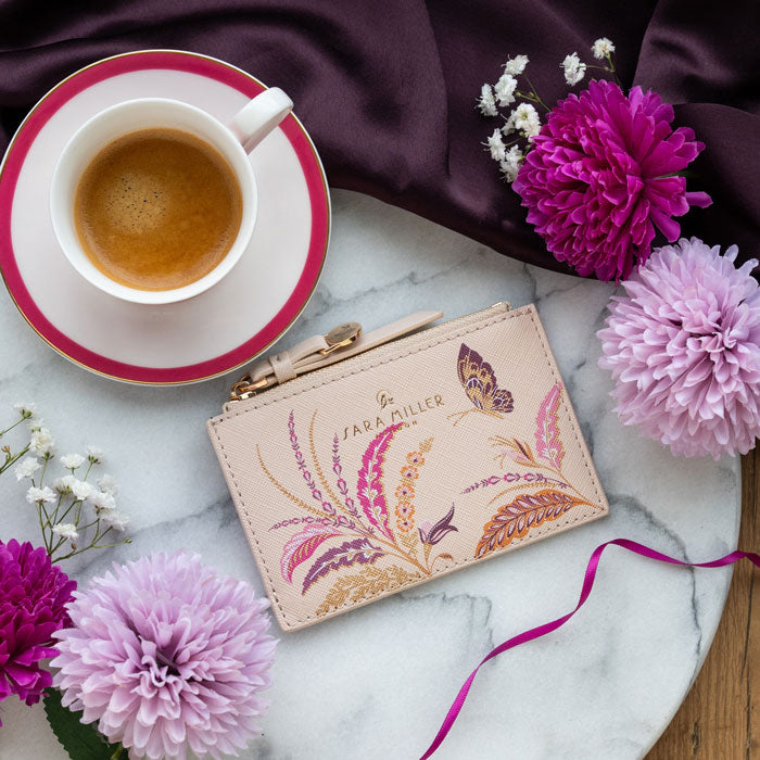 Cream card holder with floral design and zip top coin compartment.