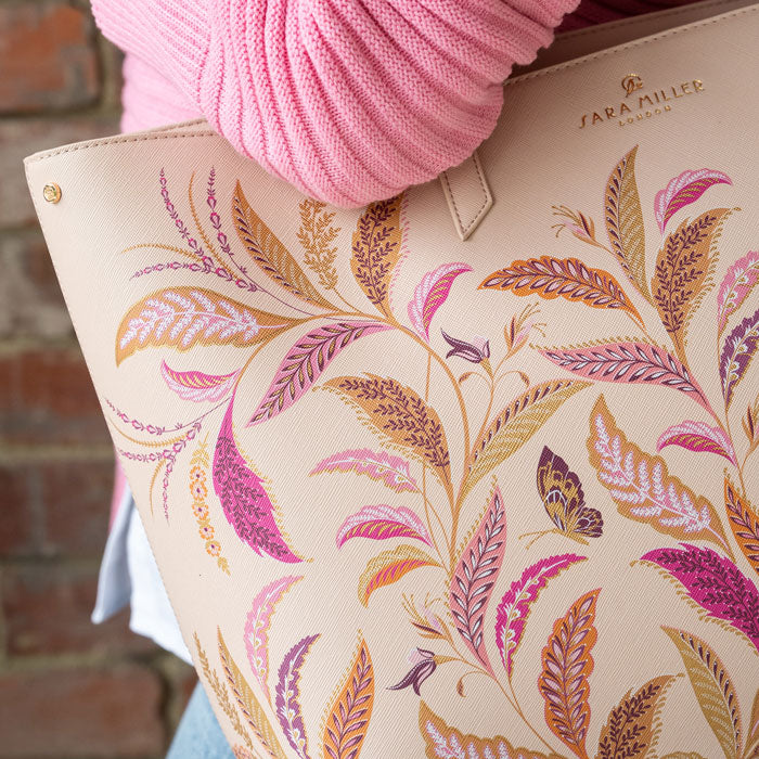Close up of floral pattern on cream bag, can see texture of bag material.