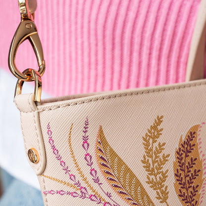Close of of gold clip which attaches strap to the bag.