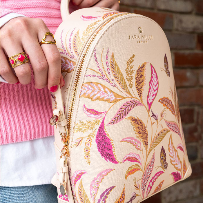 Person holding mini backpack, close up of pattern and zips.