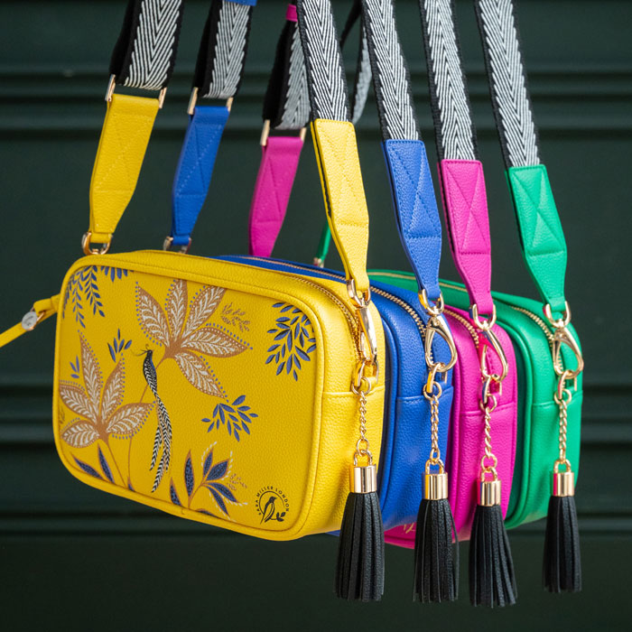 Yellow handbag next to others from the collection, in blue, pink and green.