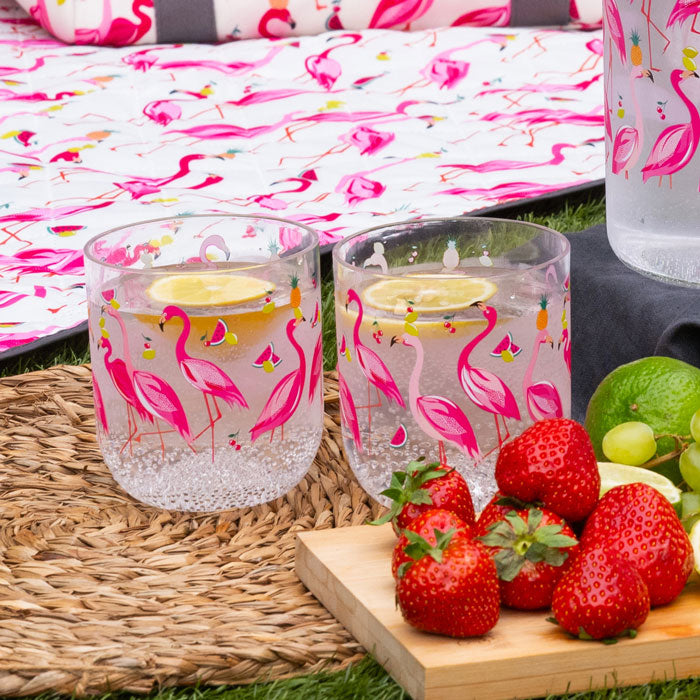 Two clear plastic cups with flamingo design, full of water with lemon slices.