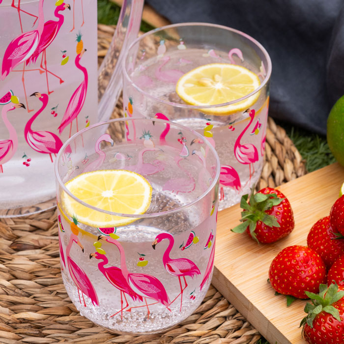 Two clear plastic cups with flamingo design, full of water with lemon slices.