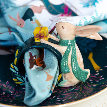 The napkin ring with matching napkin styled inside on a place setting.