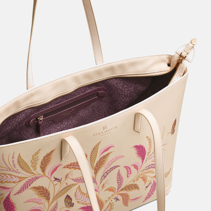 Shows inside of bag with soft plum lining and delicate leaves pattern and zip pocket..