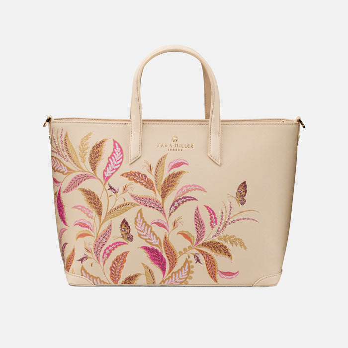 Cream tote style handbag with floral pattern on a white background