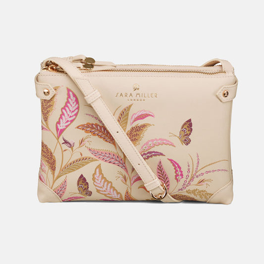 Cream crossbody handbag with floral design, double compartments with zip closures.