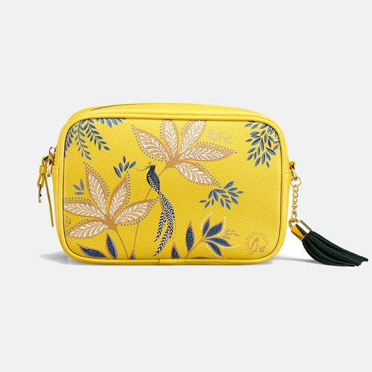 Yellow crossbody bag with floral design and black tassel.