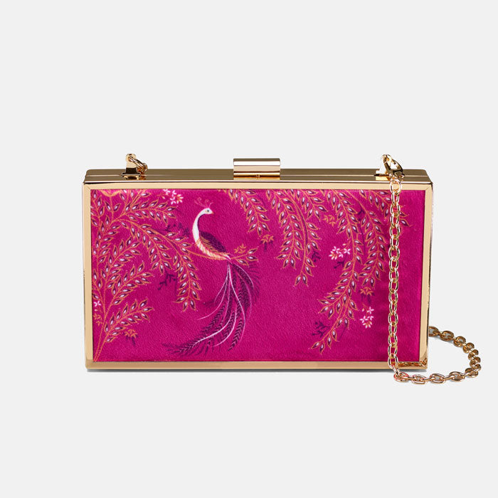 Pink clutch bag with peacock design and gold chain on a pink backdrop