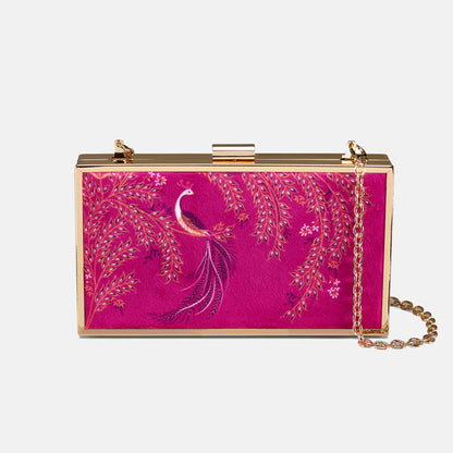 Pink clutch bag with peacock design and gold chain on a pink backdrop