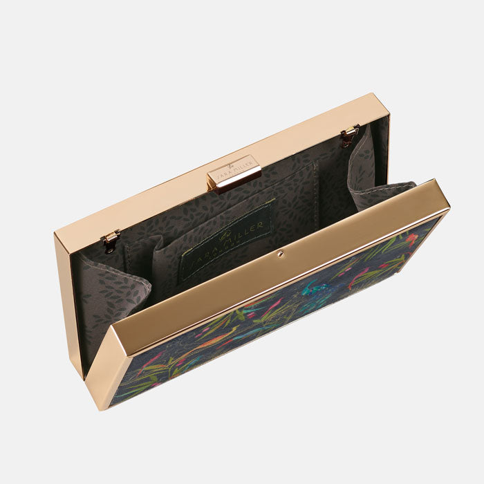 Inside of clutch bag, shows delicate leaf patterned lining and gold clasp detail.