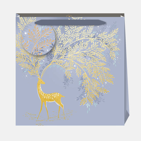 Gift bag with gold deer and leaf design on a light blue background
