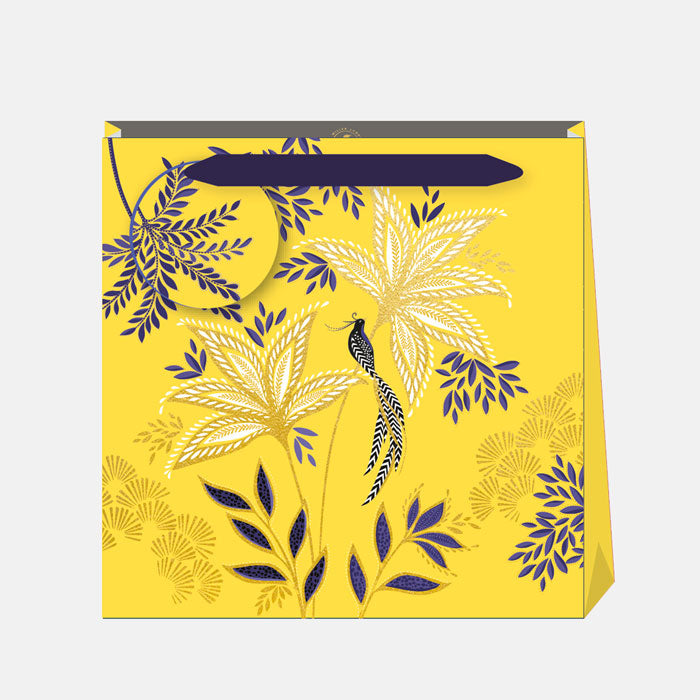 Warm yellow gift bag in botanic blooms design, with matching gift tag and indigo ribbon handles.