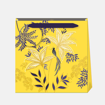Warm yellow gift bag in botanic blooms design, with matching gift tag and indigo ribbon handles.