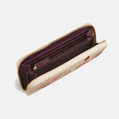 Shows inside of purse with soft plum lining and delicate leaves pattern, internal zip pocket and card slots.