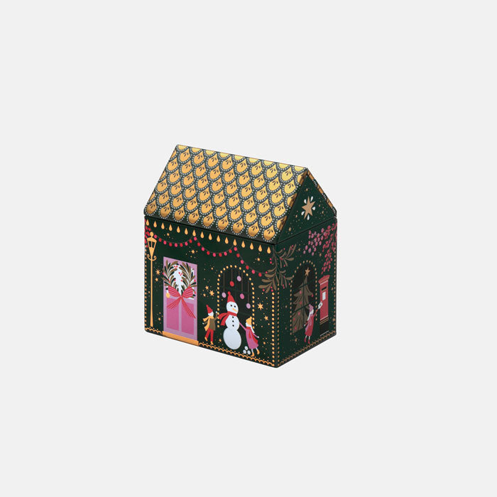 A small decorative house-shaped tin with a gold patterned roof and a dark green front decorated with festive illustrations including a snowman, a pink front door, and holiday lights.