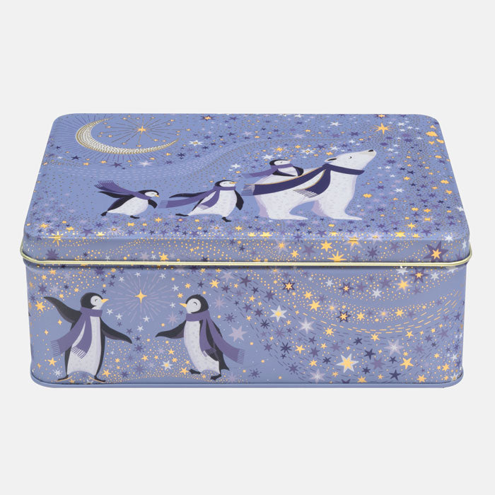A rectangular metal tin box decorated with a polar bear, penguins, stars, and a crescent moon on a light blue background.