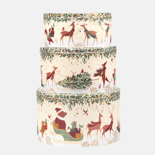 Set of three stacked cylindrical cake tins with festive animals and Christmas tree design on a white background
