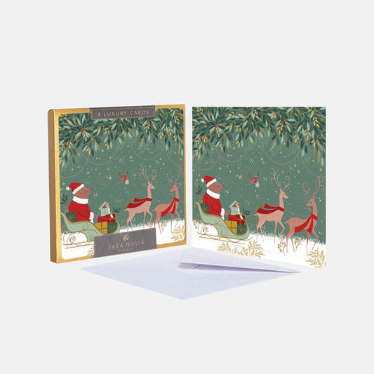 Set of Christmas-themed greeting cards with Santa and reindeer design, featuring a box of cards on a white background.