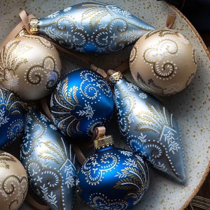 Decorative blue and beige ornaments with intricate patterns on a textured surface.