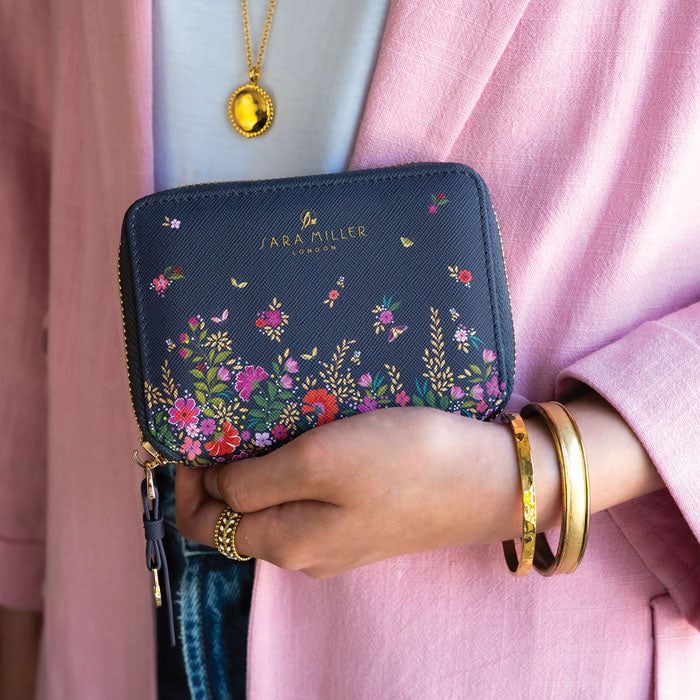 Model holding ditsy floral small purse, can see scale.
