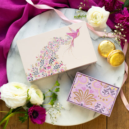 Small rectangular tin with hummingbird design and floral details, pink and beige shades.