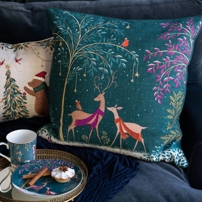 Decorative pillows with festive designs on a couch, including a mug and plate with food.