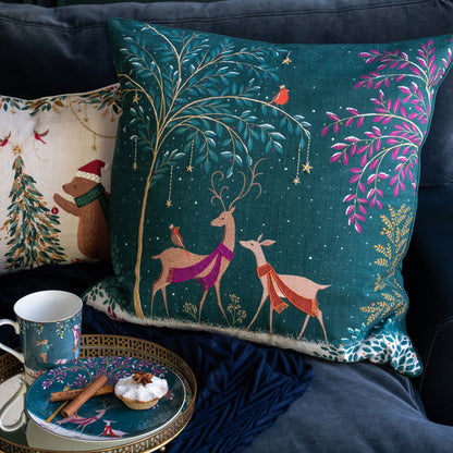 Decorative pillows with festive designs on a couch, including a mug and plate with food.