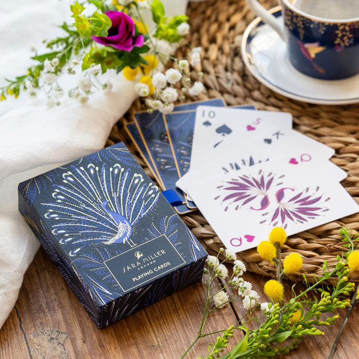 Playing cards with peacock feathers design on an indigo background. Shows presentation box in matching design.