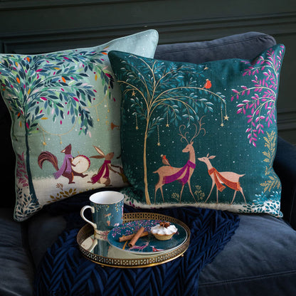 Decorative pillows with festive designs on a sofa with a small table and mug.