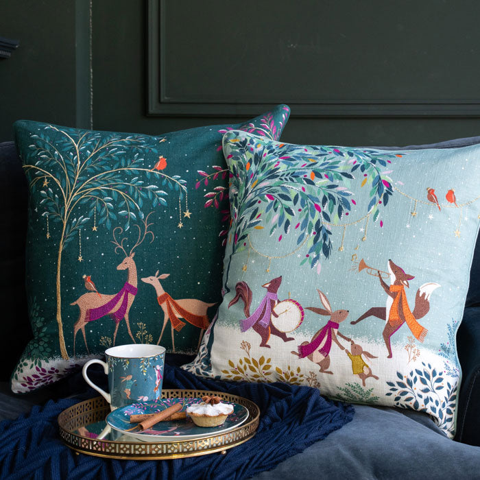 Festive cushions on a sofa with matching mug.