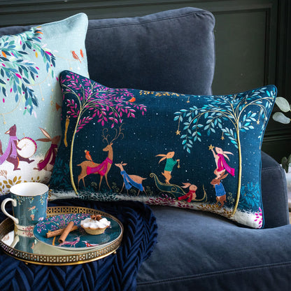 Decorative pillows with festive designs on a couch, accompanied by a small table with a mug.