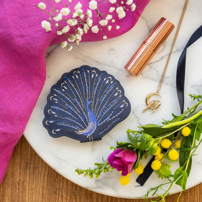 Compact mirror shaped like a peacock with blue and gold peacock design.