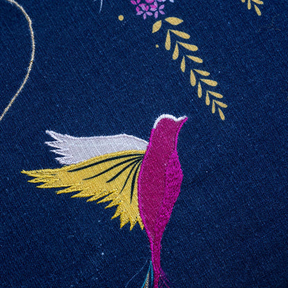Close up of hummingbird design with embroidery and linen texture.