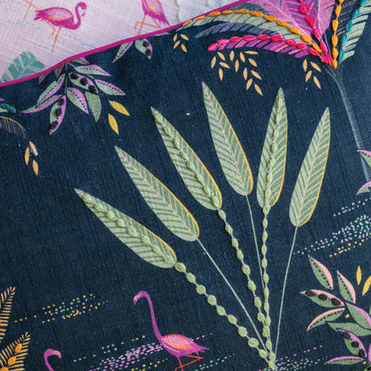 Close-up of fabric with tropical leaf and flamingo pattern on a navy background, linen texture.