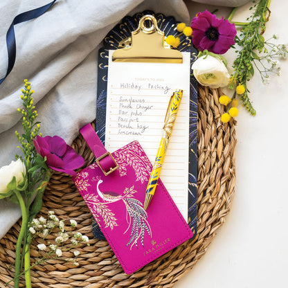 Fuchsia luggage tag with elegant bird design and gold detailing, buckle fastening.