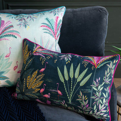 Decorative pillows with floral and flamingo patterns on a dark sofa.