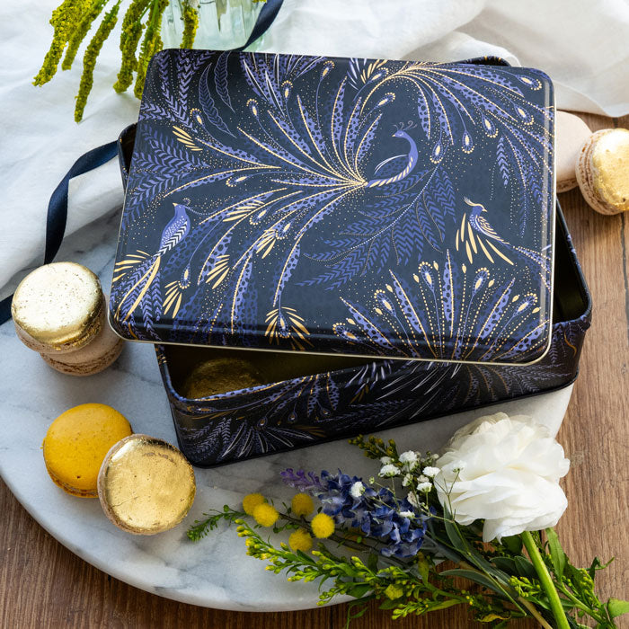 Rectangular tin featuring peacock parade design with swooping tail feathers, in velvety indigo.