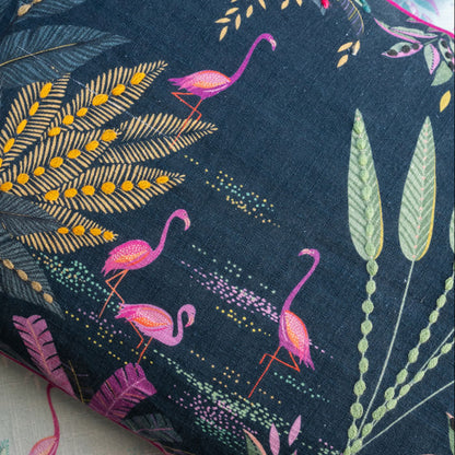 Close-up of fabric with tropical leaf and flamingo pattern on a navy background, linen texture.