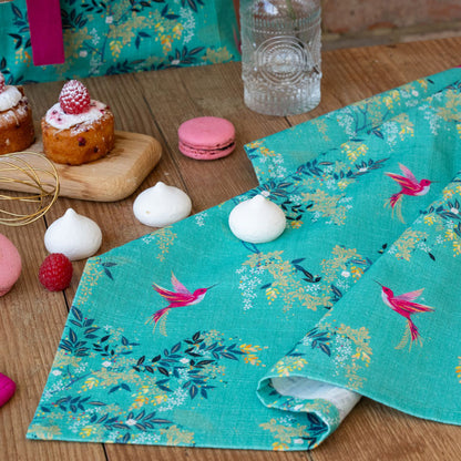 Green tea towel with hummingbird and foliage design.